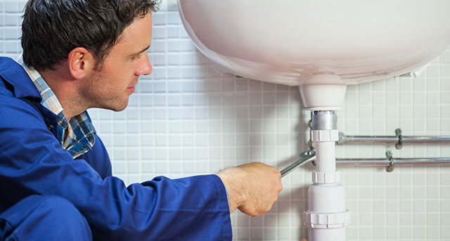 technician repairing commercial sink